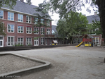 Speelplaats. Links deel hoofdgebouw, rechts vleugel Johann Keplerstraat.
<br/>
Corrie Groen- Pickhard, 2016-06-12